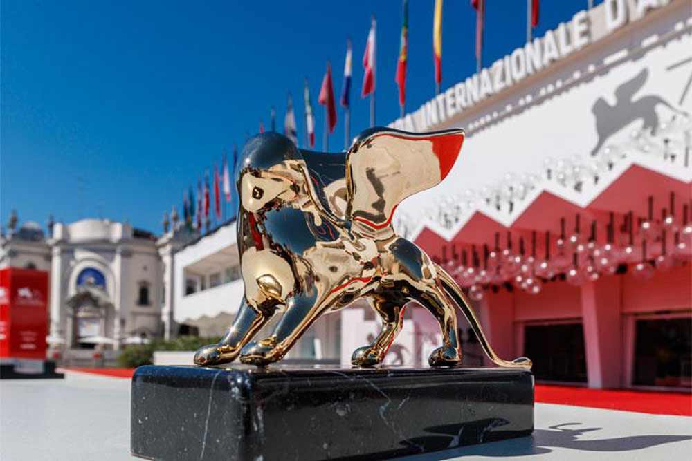 Il leone d'oro con il palazzo della mostra cinematografica di Venezia