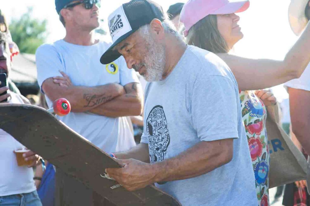 Steve Caballero autografa una tavola da skate durante il Wheels and Waves