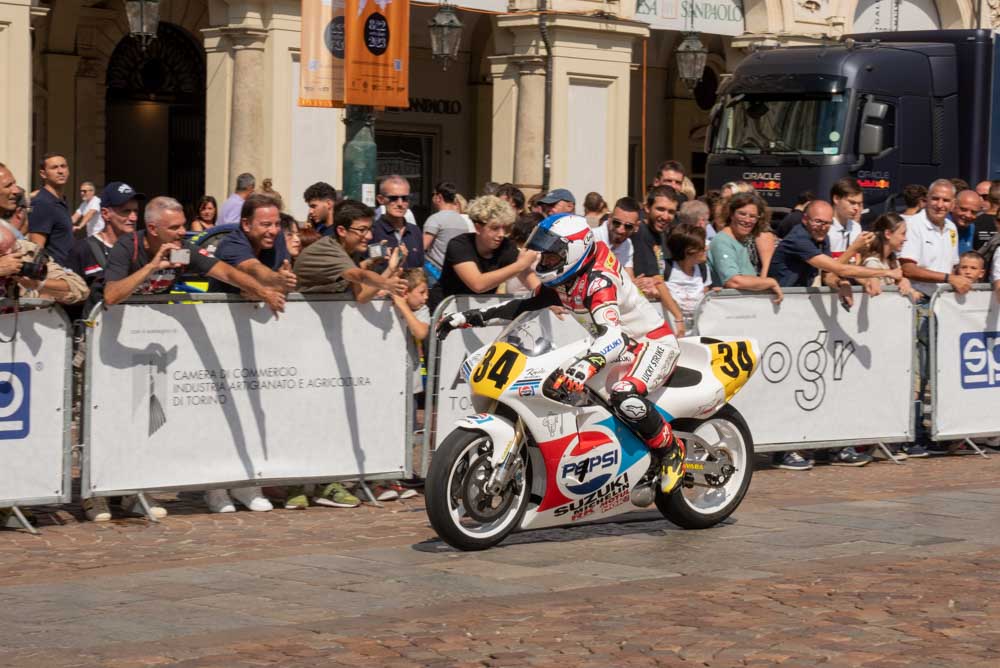 Kevin Schwantz in sella alla Suzuki #34 saluta il pubblico di piazza San Carlo